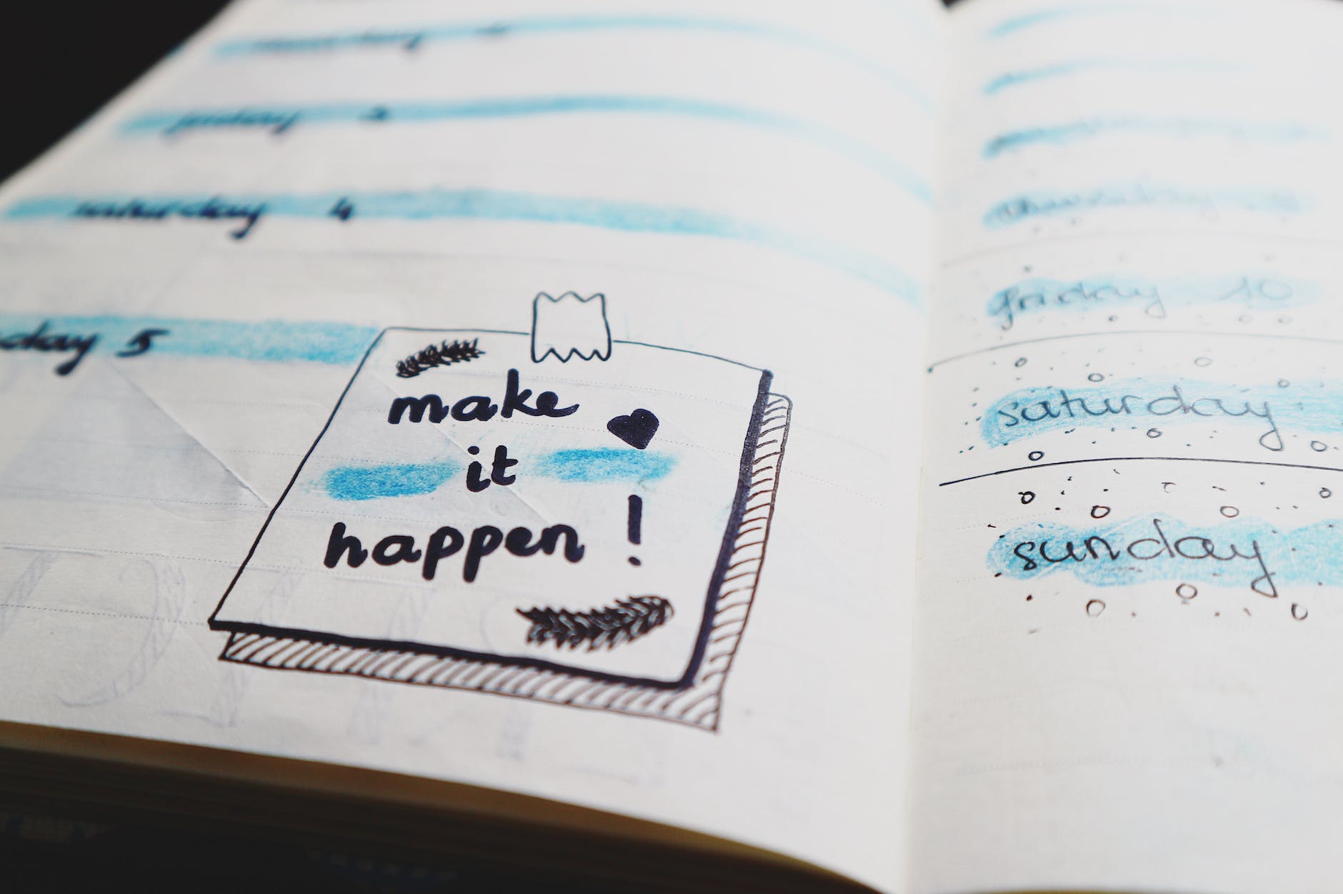 Handwritten note in an open notebook saying "make it happen"